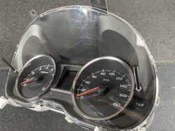 Car instrument cluster with tachometer on the left and a speedometer up to 180 km/h; clear panel shows scratches and bezel gaps.