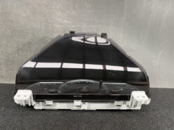 Front view of a car instrument cluster housing: a curved black display with gauge elements visible at the bottom, mounted on white plastic brackets and clips.