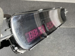 Close-up of a black, curved visor with a pink digital readout visible through the lens (likely a goggle HUD).