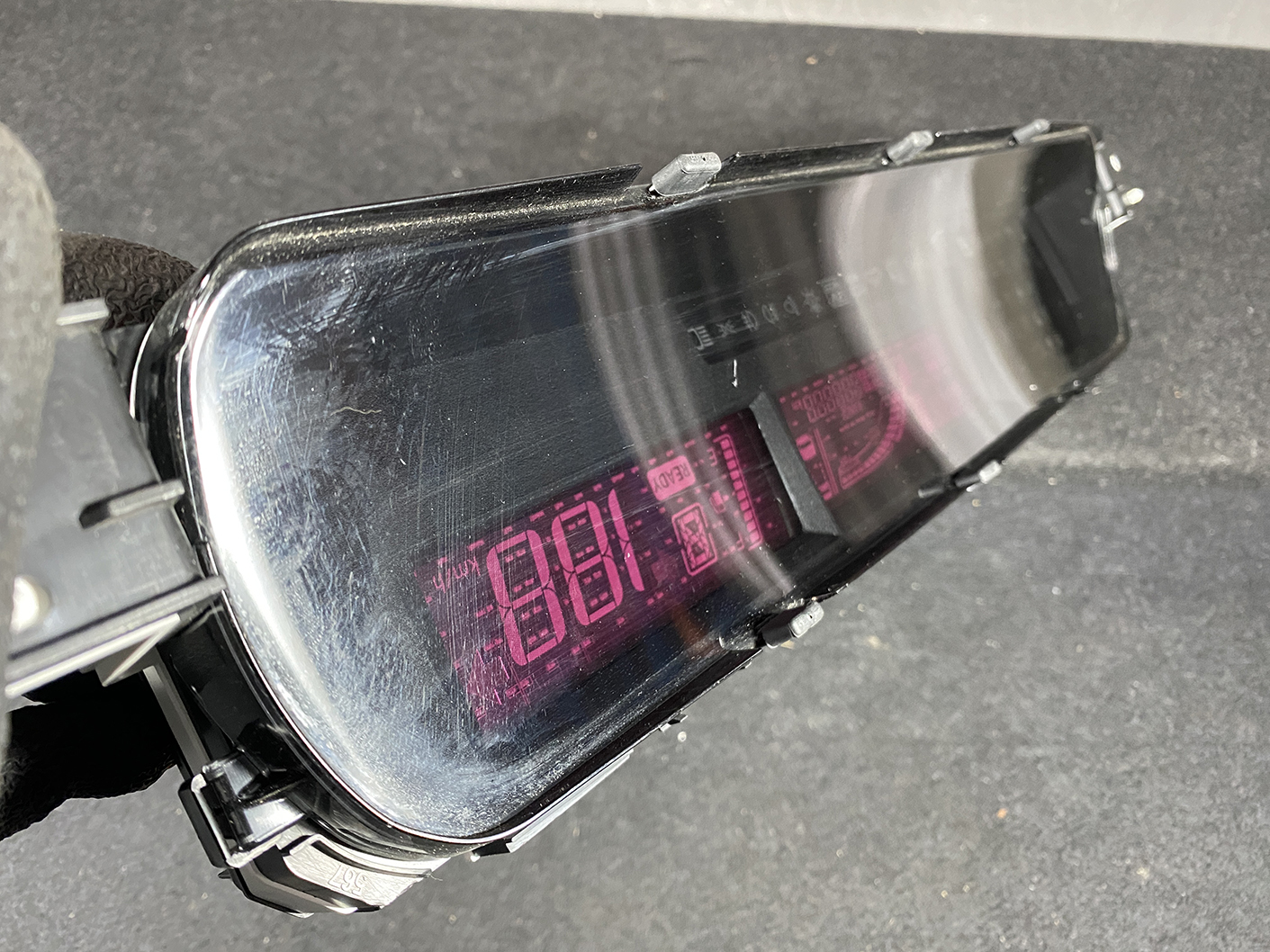 B473_10 TOYOTA PRIUS C AQUA NHP10 Genuine Instrument Cluster 83800-5CU90 » NZ1.95 » JDM-PARTS NZ » JDM-PARTS NZ Close-up of a black, curved visor with a pink digital readout visible through the lens (likely a goggle HUD). TOYOTA PRIUS C AQUA NHP10 Genuine Instrument Cluster 83800-5CU90 » JDM-PARTS NZ