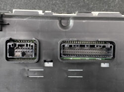 Two modular electrical connectors on a black panel: a small rectangular plug on the left and a larger multi-pin socket on the right.