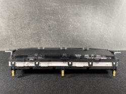 Black laser printer toner cartridge with yellow release tabs resting on a dark surface, side view.