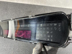 Close-up of a black car key fob with a pink digital display and many status icons.