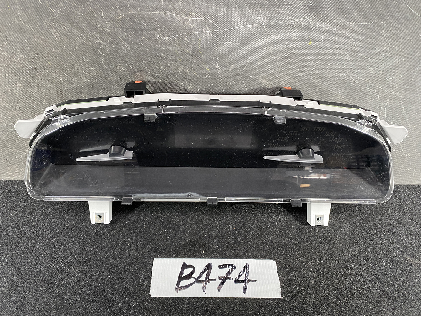 B474_2 TOYOTA SIENTA NHP170 Genuine Instrument Cluster 83800-5CP61 » NZ1.95 » JDM-PARTS NZ » JDM-PARTS NZ Automotive instrument cluster with a central digital screen and a right-hand speedometer, mounted on a dark surface with brackets above and below. TOYOTA SIENTA NHP170 Genuine Instrument Cluster 83800-5CP61 » JDM-PARTS NZ
