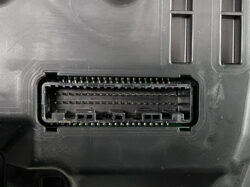 Close-up of a black rectangular automotive electronic connector receptacle with many pins inside