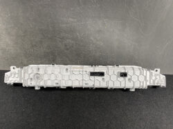 Rear view of a gray automotive instrument cluster control module with multiple connector ports and mounting points on a dark textured surface