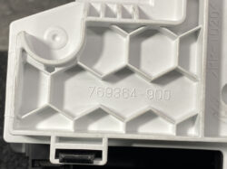 Close-up of a white plastic component with a honeycomb lattice pattern and the molded part number 769364-900.