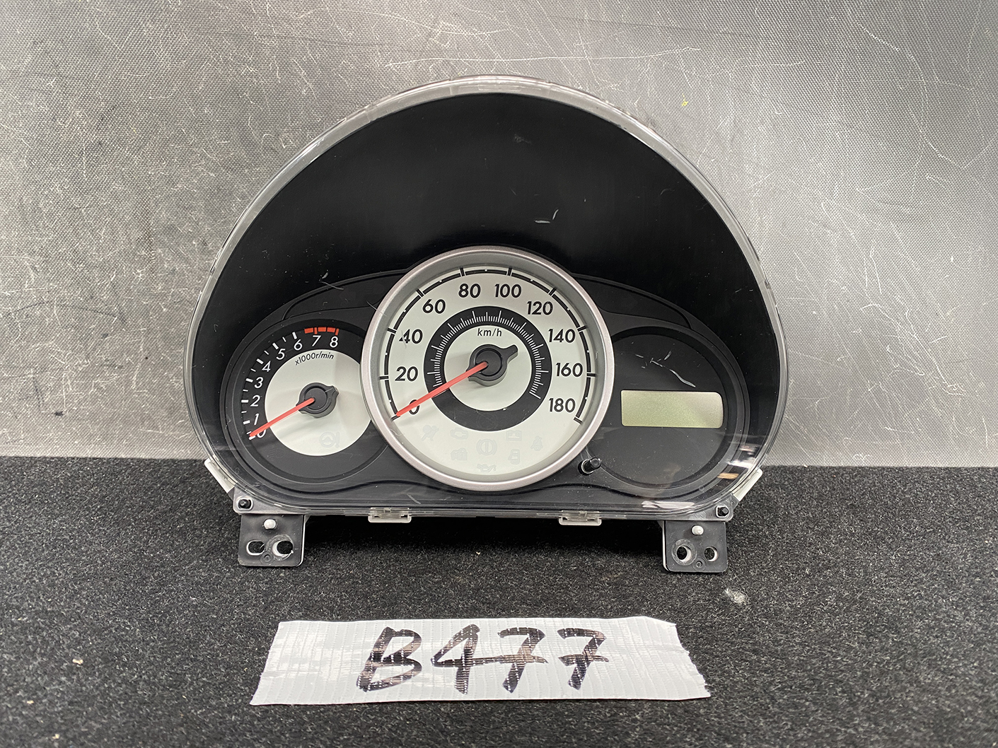 B477_2 MAZDA DEMIO MAZDA 2 DE3FS Genuine Instrument Cluster D01J55430 K9001 » NZ.95 » JDM-PARTS NZ » JDM-PARTS NZ Car instrument cluster with central speedometer and left tachometer, digital display to the right, mounted on a black dashboard panel. MAZDA DEMIO MAZDA 2 DE3FS Genuine Instrument Cluster D01J55430 K9001 » JDM-PARTS NZ