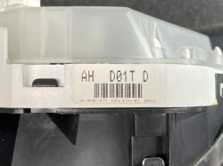 Close-up of a white plastic device with a barcode label and alphanumeric text 'AH D01T D' on it.