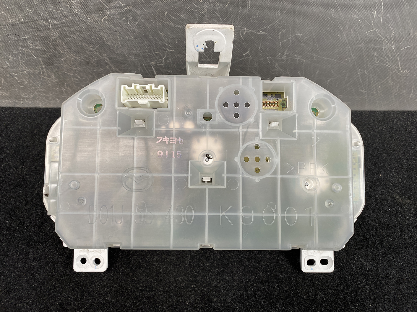 B477_6 MAZDA DEMIO MAZDA 2 DE3FS Genuine Instrument Cluster D01J55430 K9001 » NZ.95 » JDM-PARTS NZ » JDM-PARTS NZ Rear view of a car instrument cluster module with multiple electrical connectors and mounting tabs. MAZDA DEMIO MAZDA 2 DE3FS Genuine Instrument Cluster D01J55430 K9001 » JDM-PARTS NZ