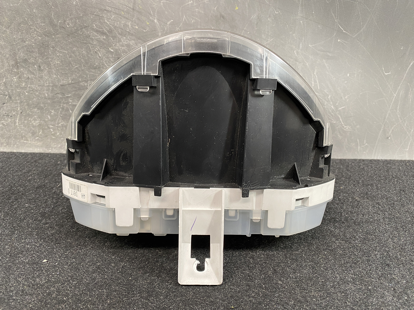 B477_7 MAZDA DEMIO MAZDA 2 DE3FS Genuine Instrument Cluster D01J55430 K9001 » NZ.95 » JDM-PARTS NZ » JDM-PARTS NZ Back view of a circular automotive instrument cluster housing with gray plastic base and black interior supports, showing mounting tabs and a clear cover edge. MAZDA DEMIO MAZDA 2 DE3FS Genuine Instrument Cluster D01J55430 K9001 » JDM-PARTS NZ