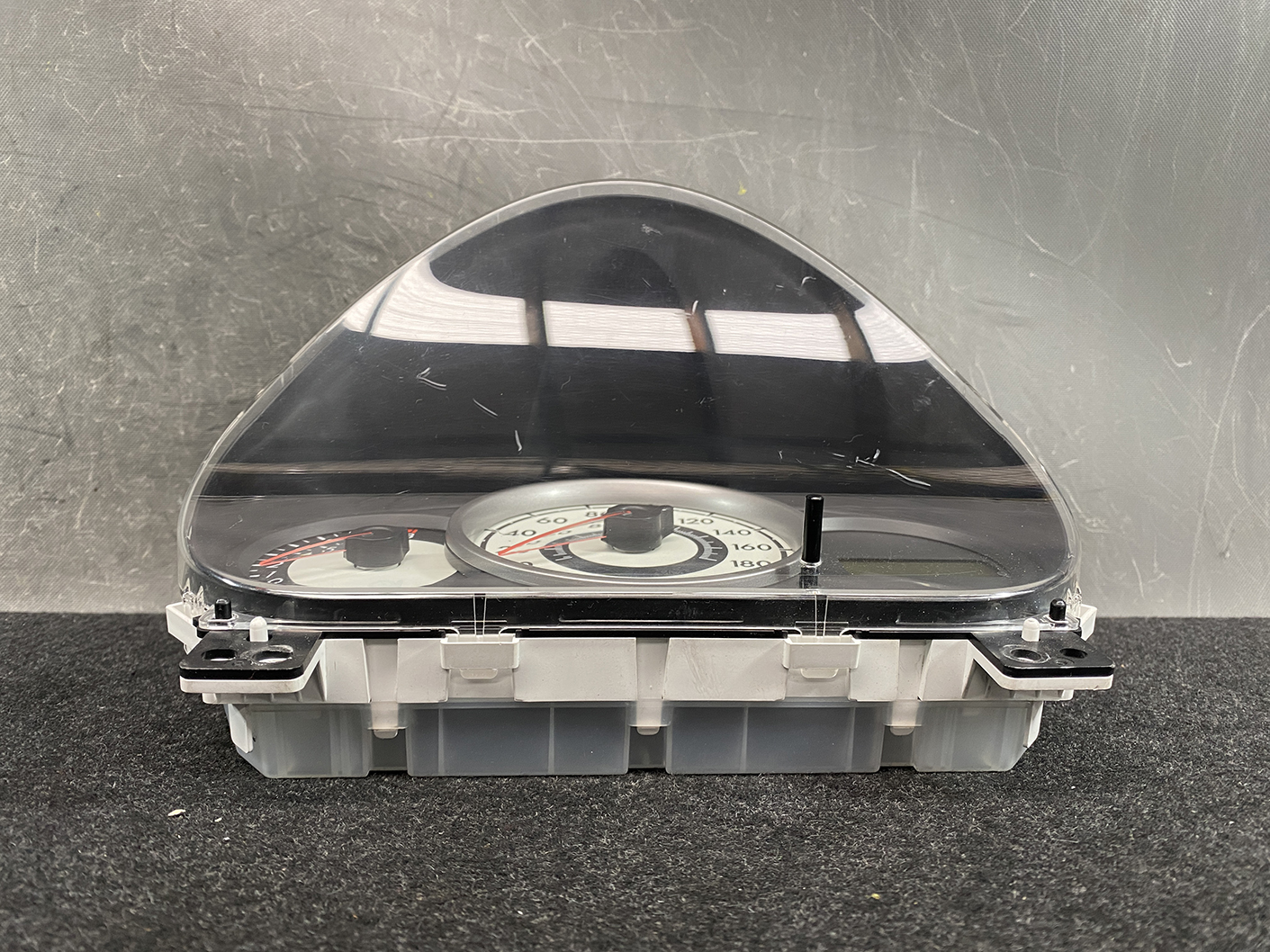 B477_8 MAZDA DEMIO MAZDA 2 DE3FS Genuine Instrument Cluster D01J55430 K9001 » NZ.95 » JDM-PARTS NZ » JDM-PARTS NZ Car instrument cluster with analog speedometer and tachometer under a curved clear cover. MAZDA DEMIO MAZDA 2 DE3FS Genuine Instrument Cluster D01J55430 K9001 » JDM-PARTS NZ