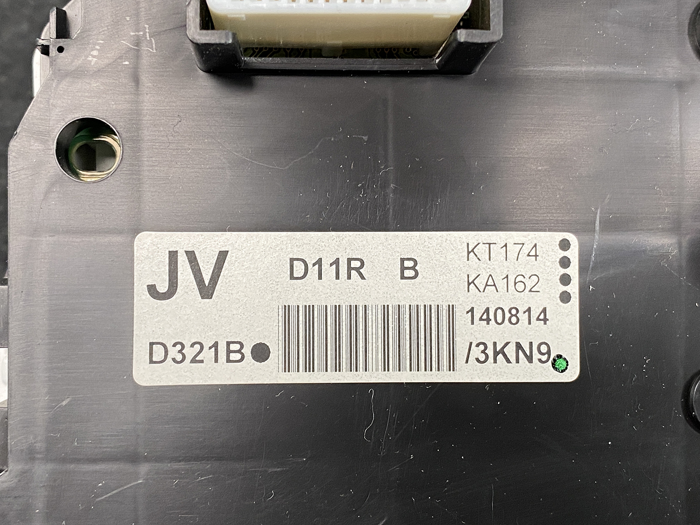 B478_3 MAZDA DEMIO CX-3 Genuine Instrument Cluster K1054 / D09M 55 430 » NZ1.95 » JDM-PARTS NZ » JDM-PARTS NZ Close-up of an electrical control module with a barcode label reading JV and D11R, plus date 140814 and small green sticker. MAZDA DEMIO CX-3 Genuine Instrument Cluster K1054 / D09M 55 430 » JDM-PARTS NZ