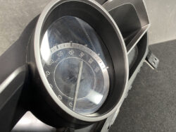Close-up of a car speedometer displaying km/h, with the needle near 0.