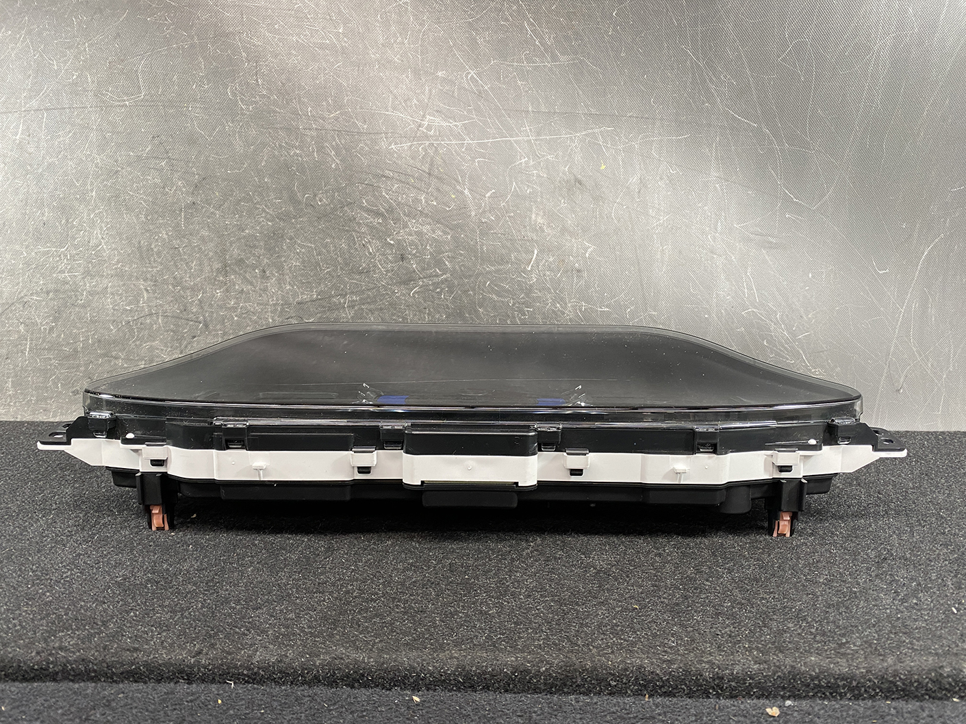 B479_6 SUZUKI SOLIO MITSUBISHI DELICA D2 Instrument Cluster 34111-81PS0 / 34104-81PA » NZ1.95 » JDM-PARTS NZ » JDM-PARTS NZ Automotive instrument cluster or dashboard screen module with mounting brackets, resting on a black surface. SUZUKI SOLIO MITSUBISHI DELICA D2 Instrument Cluster 34111-81PS0 / 34104-81PA » JDM-PARTS NZ