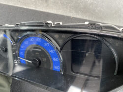 Close-up of a car instrument cluster with a blue speedometer up to 180 km/h and an off digital display to the right.