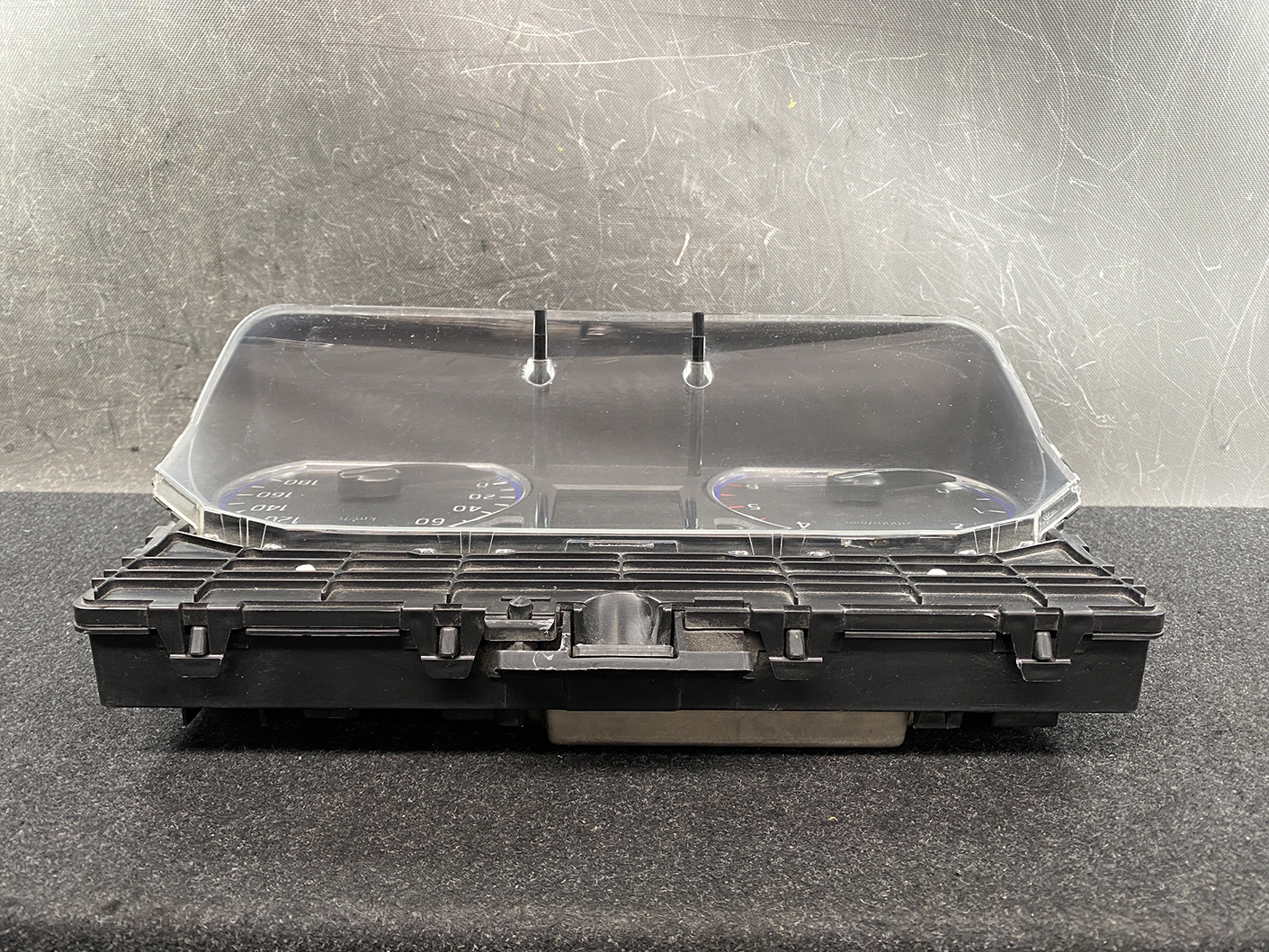 B480_6 NISSAN NV350 CARAVAN E26 Genuine Instrument Cluster 3YB0D TYPE: 883B » NZ1.95 » JDM-PARTS NZ » JDM-PARTS NZ Car instrument cluster housing with a clear curved lens over two round gauges in a black plastic dash. NISSAN NV350 CARAVAN E26 Genuine Instrument Cluster 3YB0D TYPE: 883B » JDM-PARTS NZ