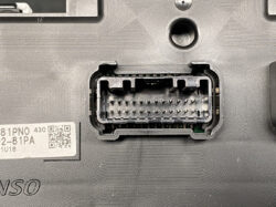 Close-up of a rectangular multi-pin electrical connector receptacle with many metal pins inside the plastic housing.