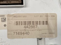 Beige shipping/parts label on a light-gray metal surface showing a barcode, part number 68235673AA, slot 03, rack 658, and a large serial 442887 with vendor 60600 details, plus a small QR code and star logo nearby.