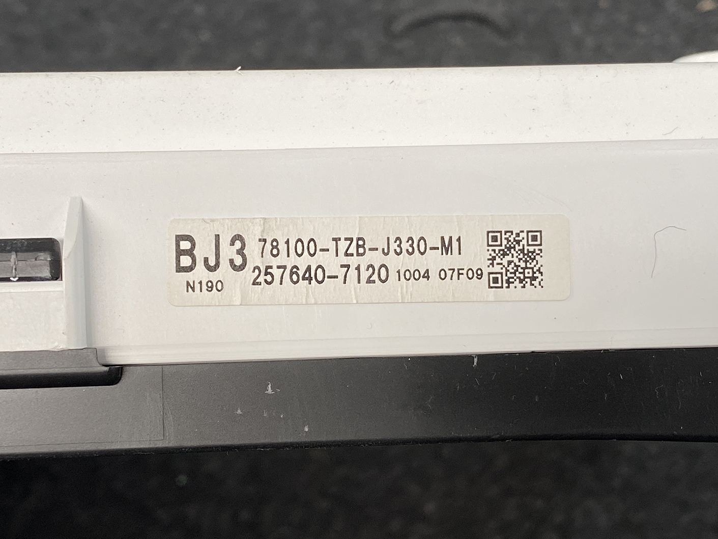 B483_4 HONDA FIT JAZZ GR6 Genuine Instrument Cluster BJ3 78100-TZB-J330-M1 » NZ1.95 » JDM-PARTS NZ » JDM-PARTS NZ Close-up of a white electronic device label showing model BJ3 78100-TZB-J330-M1 and a QR code, with serial text 257640-7120. HONDA FIT JAZZ GR6 Genuine Instrument Cluster BJ3 78100-TZB-J330-M1 » JDM-PARTS NZ