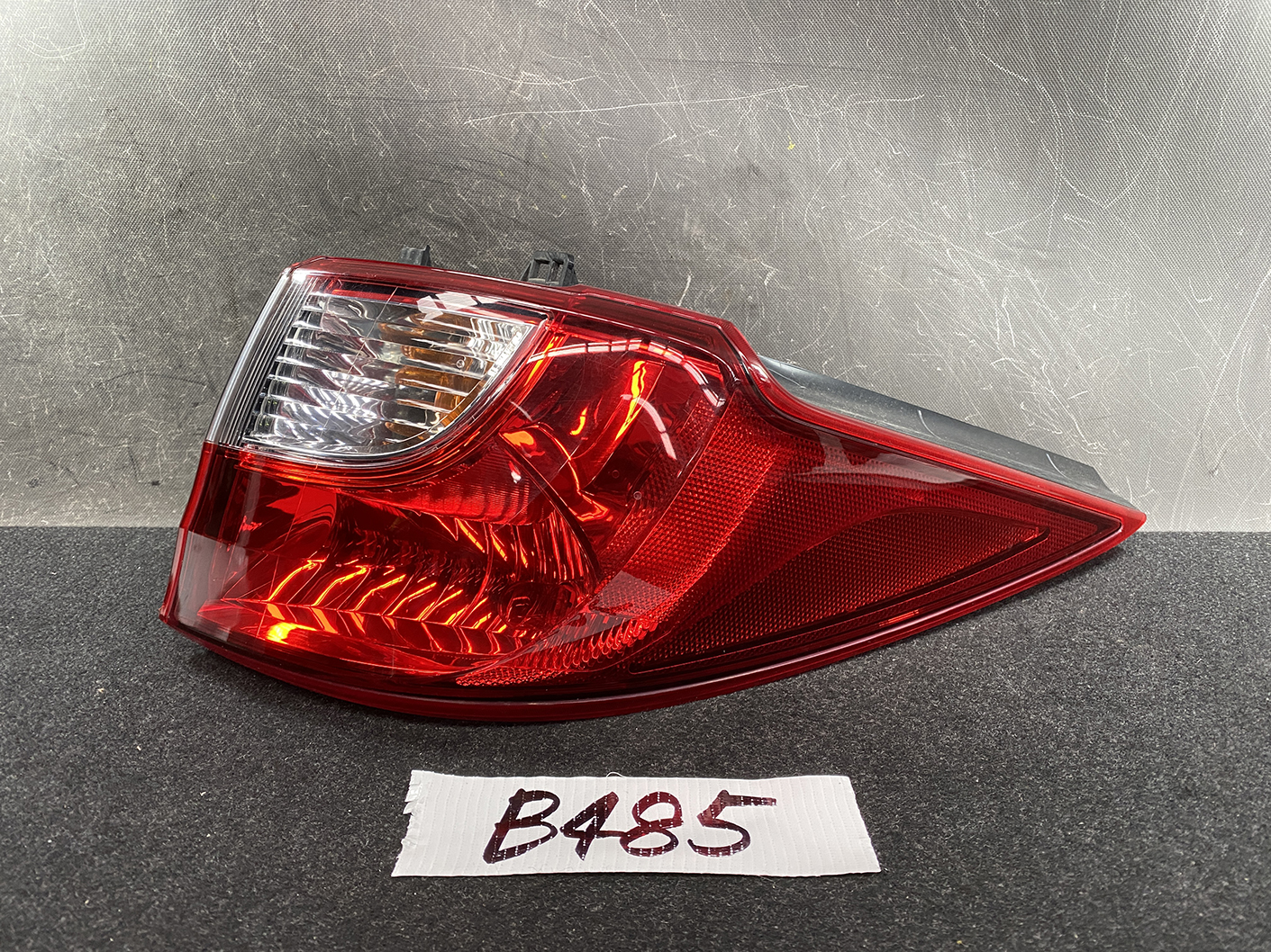 B485_1 MAZDA PREMACY CW NISSAN LAFESTA Taillight P9377 Right Side x1 » NZ1.95 » JDM-PARTS NZ » JDM-PARTS NZ Red car taillight assembly with clear reverse light section and curved shape on a dark surface. MAZDA PREMACY CW NISSAN LAFESTA Taillight P9377 Right Side x1 » JDM-PARTS NZ