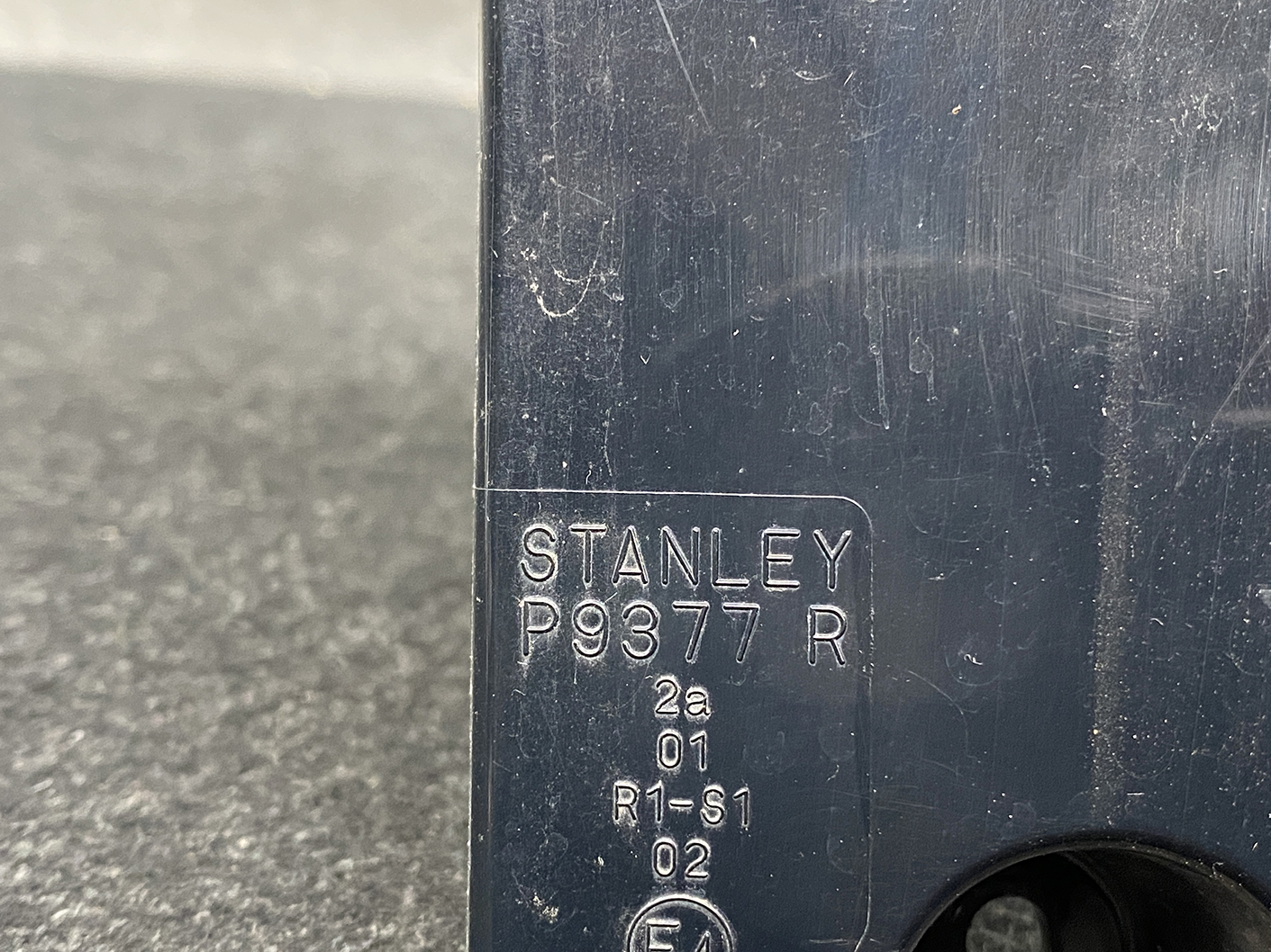 B485_2 MAZDA PREMACY CW NISSAN LAFESTA Taillight P9377 Right Side x1 » NZ1.95 » JDM-PARTS NZ » JDM-PARTS NZ Close-up of a dark metal surface with an engraved label reading STANLEY P9377 R and small codes underneath (2a 01 R1-S1 02). MAZDA PREMACY CW NISSAN LAFESTA Taillight P9377 Right Side x1 » JDM-PARTS NZ