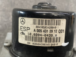 Close-up of a black automotive module with a beige label reading ESP and a barcode, likely a Mercedes part.