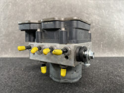 Bosch-branded ABS actuator module with a black plastic top and yellow valve levers on a metal block