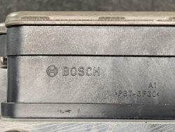 Close-up of a dusty Bosch plastic automotive module with logo and part code A1 >PBT-GF30