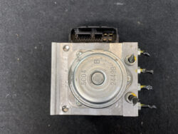 ABS brake module: square metal housing with round actuator and a multi-pin connector on top.