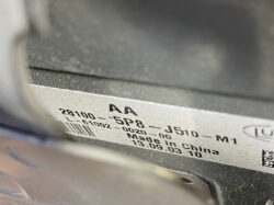 Close-up of a metal label on a vehicle component showing part numbers: 28100 5P8 J510 M1, Made in China, with date codes 13.09.03 and 10 and a barcode nearby.