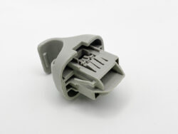 Gray plastic multi-pin electrical connector housing with internal contact slots for wires (detached component).