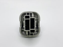 Gray plastic electrical connector shell with multiple rectangular slots, viewed from above.