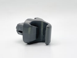 Gray plastic automotive latch/clip assembly with curved grip, viewed from the side.