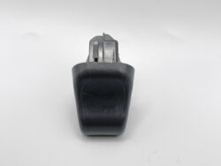 Black handheld tool with a gray metal attachment on top, photographed from the front against a white background.