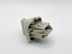 Gray plastic multi-pin electrical connector with internal contact slots, shown from the side (unmated). Deluxe close-up of a connector housing for wiring.