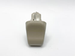 Beige plastic handheld device with a rounded back and a small metal clip at the top, viewed from the front.