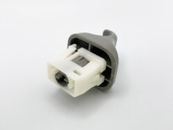 Close-up of a gray plastic switch body attached to a white two‑pin electrical connector with two wires protruding from it.
