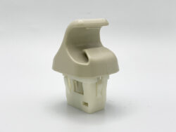 Beige plastic clip or fastener with a curved top and a rectangular base component below, likely an automotive panel fastener.