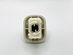 Beige plastic electrical connector housing with an inner white insert and a circular black receptacle in the center