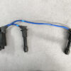 Ignition coil pack with two spark plug wires connected to spark plugs on a gray surface. MAZDA MX5 ROADSTER NB6C IGNITION COIL Pack  / DSC-510 #2 #3 » JDM-PARTS NZ
