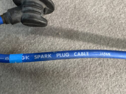 Blue automotive spark plug cable with a black connector, labeled 'SPARK PLUG CABLE JAPAN' on the blue sheath.