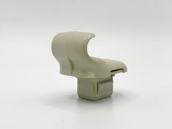 Beige plastic curved clip or bracket on a square base, photographed on a white background.