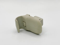 Beige curved plastic gadget with a small rectangular port on the side, shown from a side view.