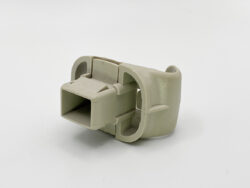 Beige plastic electrical connector housing with a hollow rectangular socket and rounded outer shell.