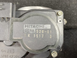 Hitachi device label reading SEPA 526-01 with serial K1517, close-up of circular housing and screws