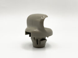 Close-up of a gray plastic toy helmet accessory with a curved dome and a bottom connector.