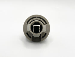Gray circular plastic connector with concentric grooves and a square central hole.