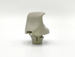 Close-up of a gray plastic toy part with interlocking tabs on a white background, viewed from the side.