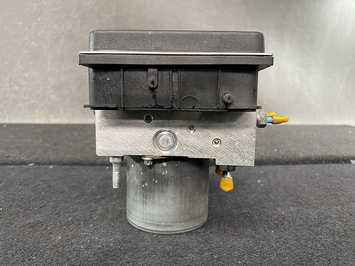 SUB-ACTR-27536SC050_12 Subaru Forester Genuine ABS Pump Module Actuator 27536SC050 » NZ9.95 » JDM-PARTS NZ » JDM-PARTS NZ Automotive hydraulic brake control unit with a black plastic top and metal housing, mounted on a cylindrical support, with yellow connector fittings on the side and bottom. Subaru Forester Genuine ABS Pump Module Actuator 27536SC050 » JDM-PARTS NZ